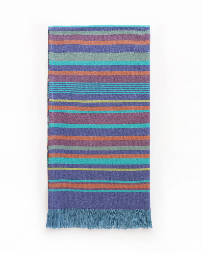 Folded view of the Mungo South Kikoi in Kai, a 100% cotton kikoi with a true selvedge, tassels, and a subtle striped pattern.