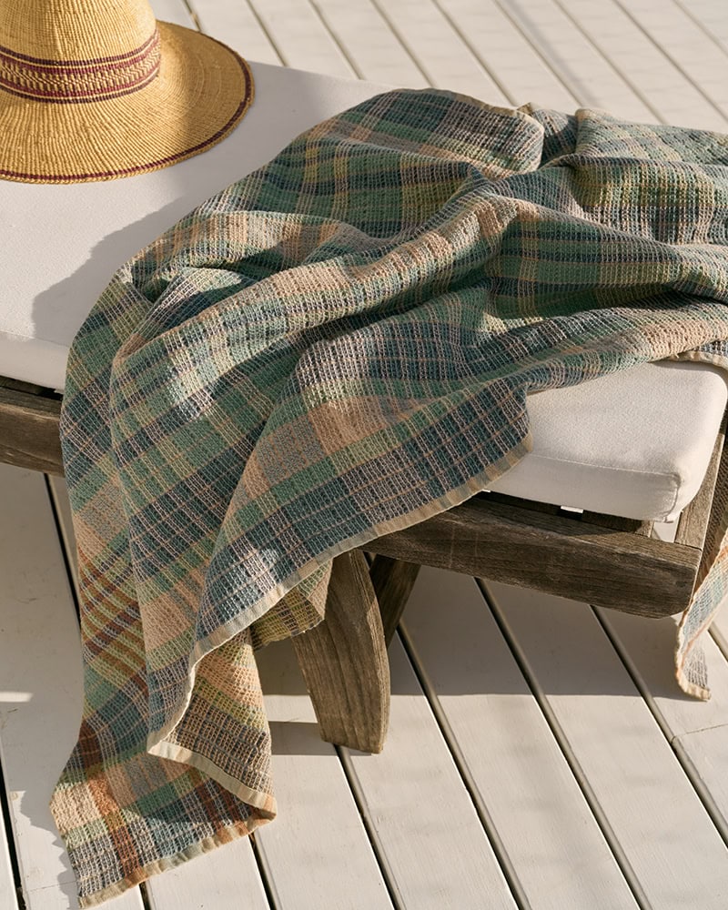 The Dolomite Waffle Weave Wayfarer towel draped over a chaise lounge