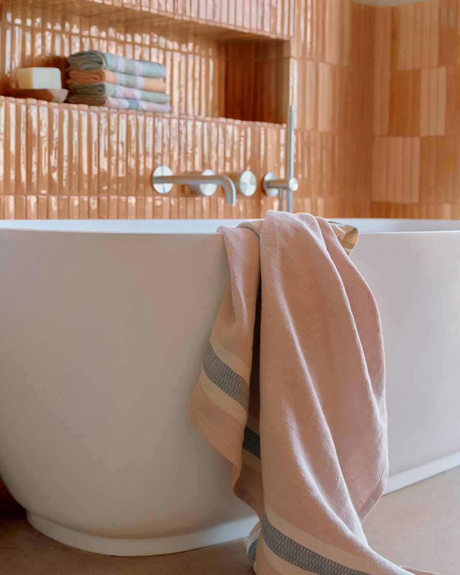 Bathroom with Mungo flax towel draped over the bath.