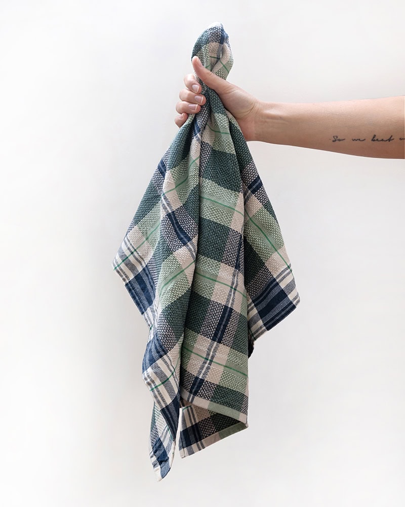 Model holding a Mungo Vadoek Tea Towel in Basil.