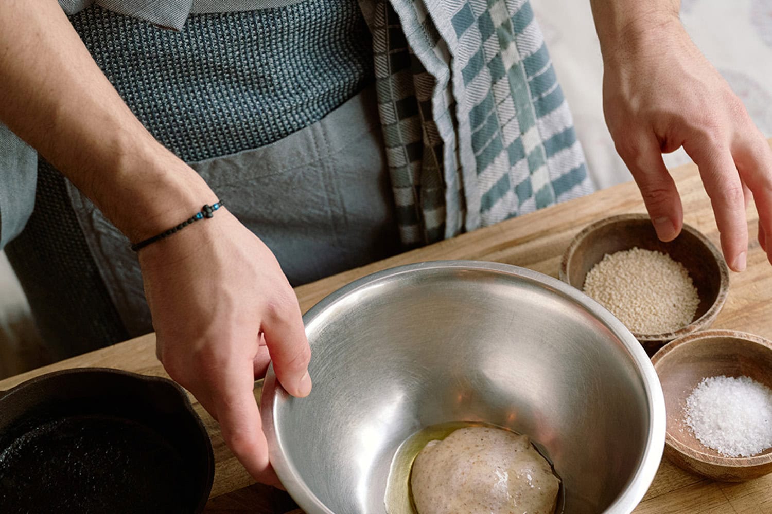 Ouzeri chef preparing dough wearing a Mungo grill apron with a Pocket Weave Tea Towel.