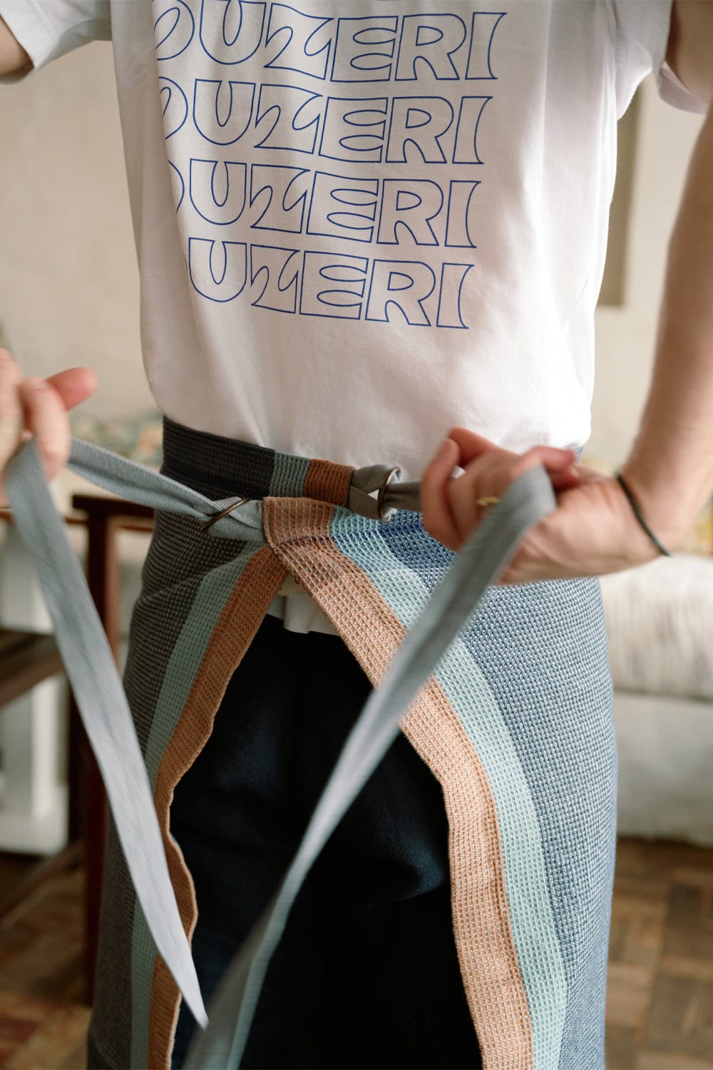 Ouzeri chef tying on a Mungo Grill Apron.