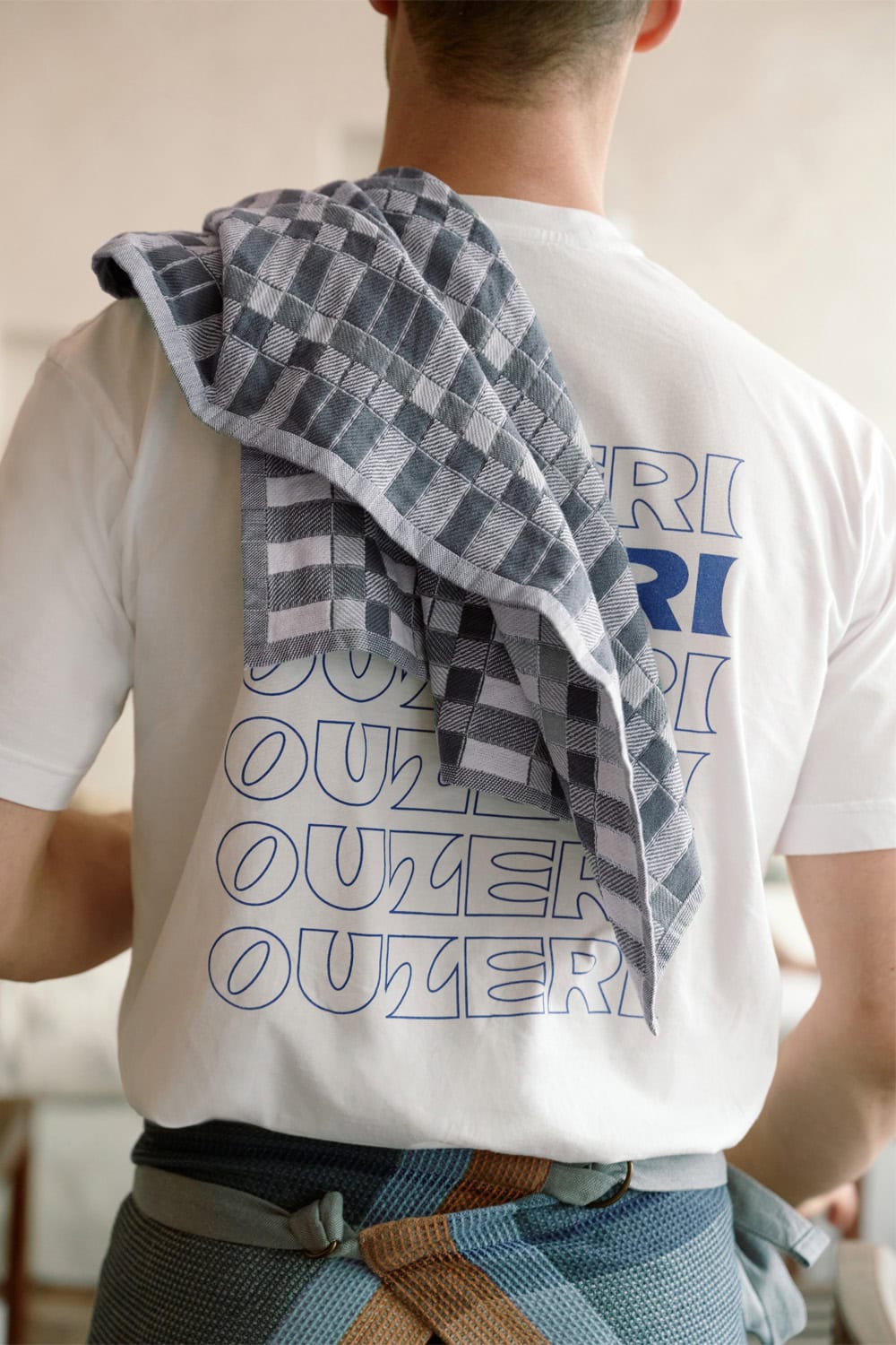 Ouzeri chef wearing a Mungo grill apron with a Pocket Weave Tea Towel.