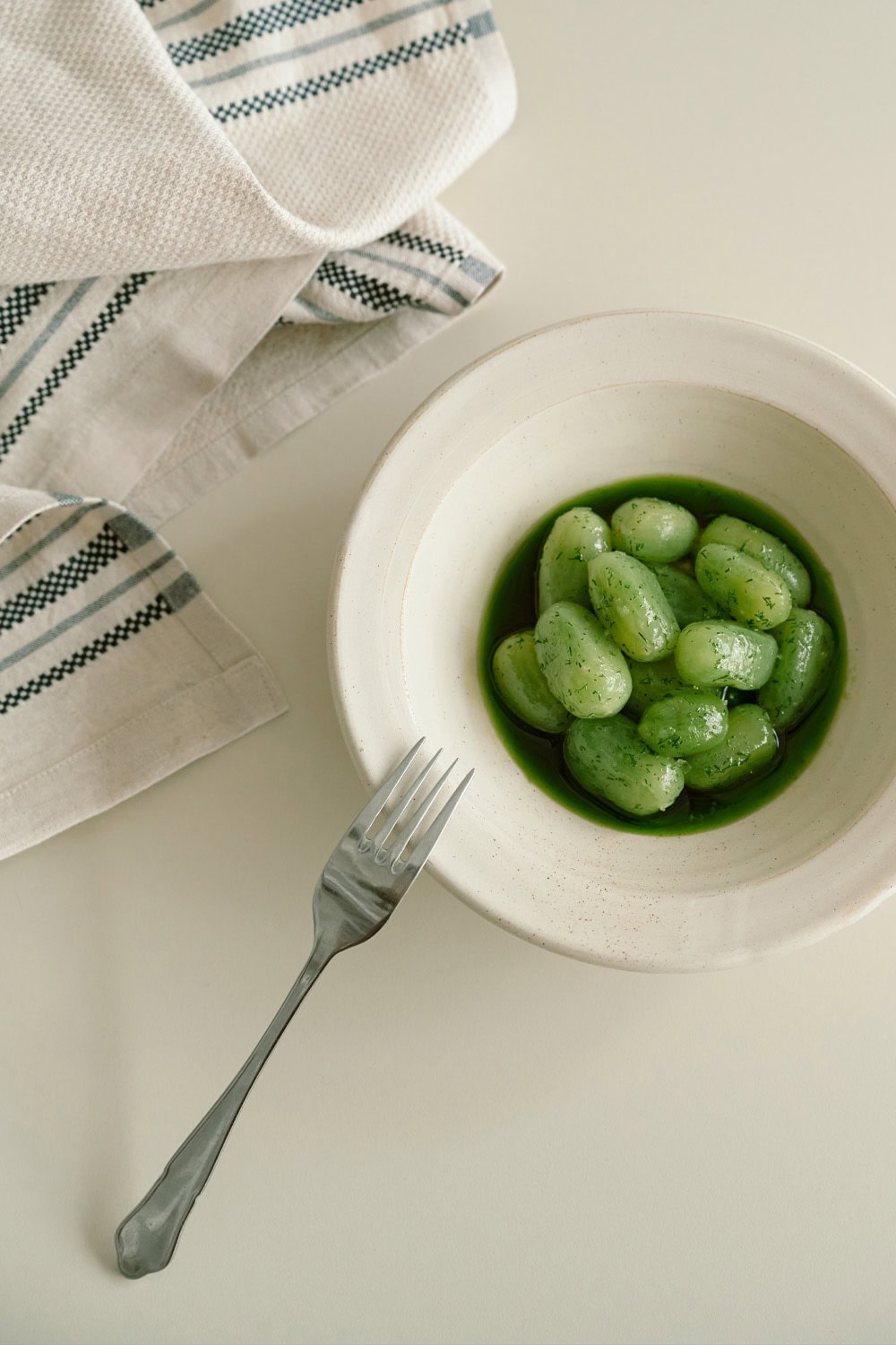 Ouzeri dish of green tomatoes in a bowl with a Mungo Utility Cloth tea towel.