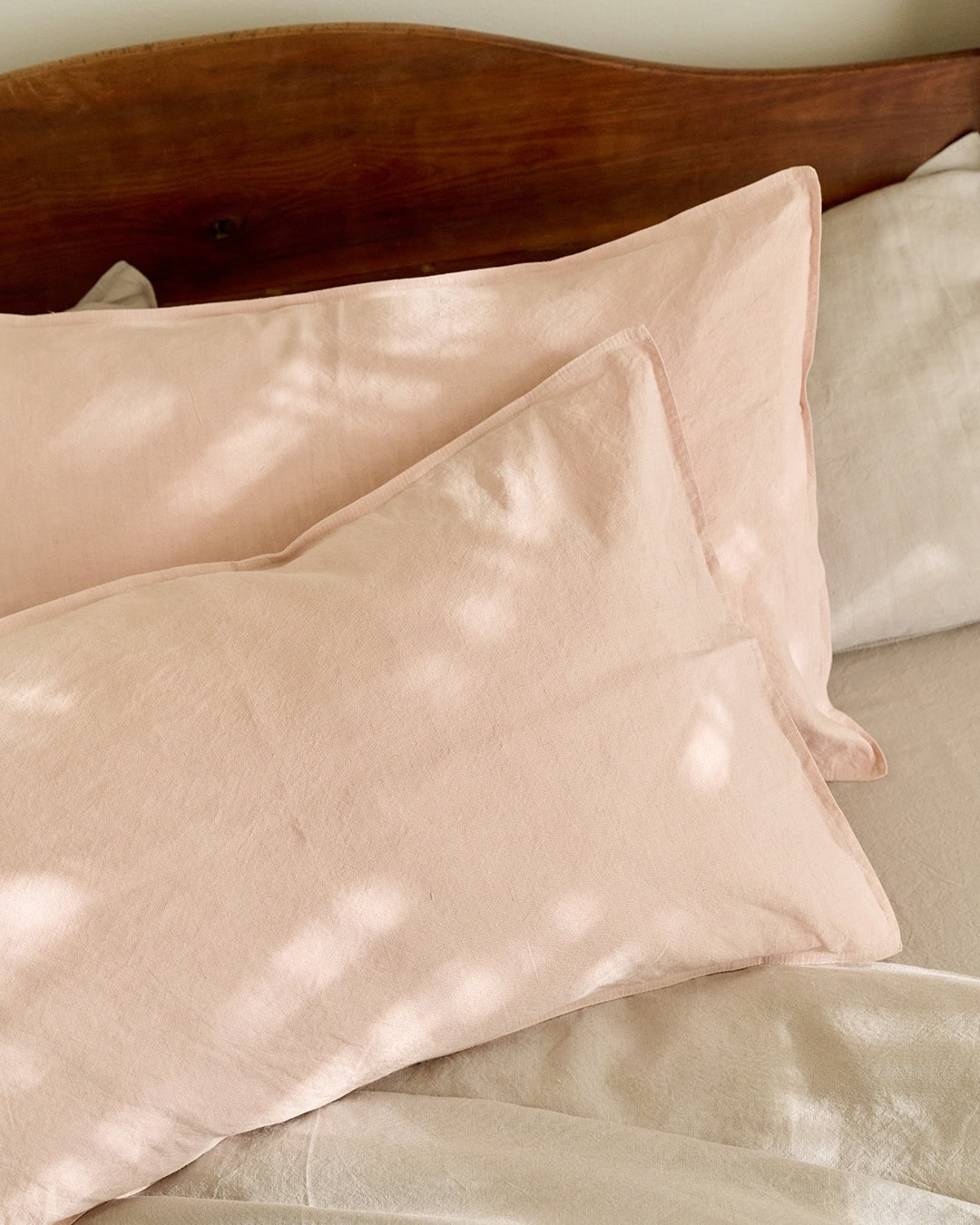 Mungo Union Cloth bedding in the Blush colourway shown on a bed.